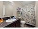 Cozy bathroom with floral shower curtain, ample storage, and a well-lit vanity area at 215 Hines Dr, Bonneau, SC 29431