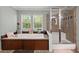 Inviting bathroom with a luxurious bathtub, glass shower, and a scenic view from the window at 215 Hines Dr, Bonneau, SC 29431