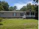 Charming one-story home featuring a cozy front porch, green lawn, and beautiful landscaping at 215 Hines Dr, Bonneau, SC 29431