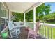 Cozy front porch with rocking chairs and swing, perfect for relaxing outdoors at 215 Hines Dr, Bonneau, SC 29431