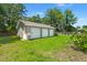 Exterior of the property with detached three car garage, green grass, and partial view of the above-ground pool at 215 Hines Dr, Bonneau, SC 29431