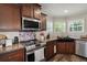 This updated kitchen offers stainless appliances, tile backsplash, a farmhouse sink, and a smooth cooktop at 215 Hines Dr, Bonneau, SC 29431