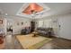 Comfortable living room with tray ceiling, plush seating, and wood-look flooring at 215 Hines Dr, Bonneau, SC 29431