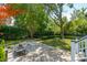 Beautifully landscaped backyard with a stone patio, lush greenery, and mature trees at 220 Ponsbury Rd, Mount Pleasant, SC 29464