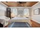 Cozy bedroom with natural light from the windows, wood floors, and a comfortable bed at 2218 Myrtle Ave, Sullivans Island, SC 29482