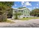 Inviting home featuring raised construction, a charming balcony, and pristine landscaping at 2218 Myrtle Ave, Sullivans Island, SC 29482