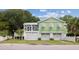 Stylish light-green home with white trim, garage, and a charming balcony, blending coastal elegance at 2218 Myrtle Ave, Sullivans Island, SC 29482