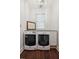 Well-organized laundry room with front load washer and dryer, light fixture, wooden floors, and bright lighting at 2218 Myrtle Ave, Sullivans Island, SC 29482