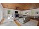 Spacious living room features a fireplace, comfortable seating, wood ceiling, and a seamless flow to adjacent areas at 2218 Myrtle Ave, Sullivans Island, SC 29482
