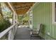 Relaxing covered porch with a chair, and wooden floors offer a cozy space to enjoy the outdoors at 2218 Myrtle Ave, Sullivans Island, SC 29482