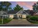 Charming single-story home with inviting curb appeal enhanced by colorful twilight skies at 2438 Hansard Dr, North Charleston, SC 29406