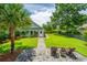 Secluded backyard featuring a patio, palm tree, green lawn, and pathway to the house at 2800 River Vista Way, Mount Pleasant, SC 29466