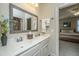 Bathroom with double sinks, white cabinets, framed mirror, and view into bedroom at 2800 River Vista Way, Mount Pleasant, SC 29466
