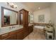 Bathroom featuring tiled floor and walls, dual sinks, a soaking tub and access to a walk-in closet at 2800 River Vista Way, Mount Pleasant, SC 29466