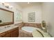 Bright bathroom featuring tiled floor and walls, a soaking tub, and a vanity area at 2800 River Vista Way, Mount Pleasant, SC 29466