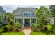Beautifully landscaped home with a charming front porch, showcasing its inviting curb appeal and well-maintained yard at 2800 River Vista Way, Mount Pleasant, SC 29466