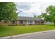 Traditional brick home featuring a manicured lawn, black shutters, and a welcoming entrance at 2942 Foxhall Rd, Charleston, SC 29414