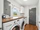Laundry room with a wood countertop, washer and dryer, a utility sink, and a window at 2942 Foxhall Rd, Charleston, SC 29414