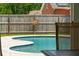 Backyard pool with a curved design, sun decoration on fence, and surrounding greenery at 2942 Foxhall Rd, Charleston, SC 29414