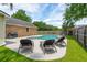 Backyard pool area featuring dark lounge chairs, brick home exterior, and a well maintained yard at 2942 Foxhall Rd, Charleston, SC 29414