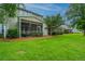Backyard view of a home with a screened-in porch and well-maintained lawn at 3012 Candela Grove Dr, Charleston, SC 29414