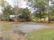 Residential property with a gravel driveway and ample outdoor parking, surrounded by mature trees at 3034 Maybank Hwy, Johns Island, SC 29455