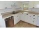 Well-lit kitchen features white cabinets and tile flooring with a stainless steel dishwasher at 3034 Maybank Hwy, Johns Island, SC 29455