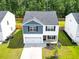 An aerial view of a two-story home with a gray roof, blue and white siding, and a manicured lawn at 304 Torslanda Ln, Summerville, SC 29486