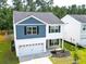 An aerial view of a two-story home with blue and white siding, a gray roof, and a well-maintained lawn at 304 Torslanda Ln, Summerville, SC 29486