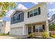 Two-story home with blue and white siding, a stone facade, a two-car garage, and well-maintained landscaping at 304 Torslanda Ln, Summerville, SC 29486