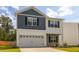 Two-story home featuring blue and white siding, a stone facade, a two-car garage, and a well-kept lawn at 304 Torslanda Ln, Summerville, SC 29486