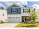 Charming two-story home featuring blue and white siding, a stone facade, and an attached two-car garage at 304 Torslanda Ln, Summerville, SC 29486