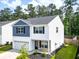 Two-story home with gray roof, blue and white siding, a stone facade, and a well-kept lawn at 304 Torslanda Ln, Summerville, SC 29486