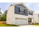 Two-story home with blue and white siding, a stone facade, a two-car garage, and a well-manicured lawn at 304 Torslanda Ln, Summerville, SC 29486