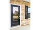 Townhome entry featuring a glass-paneled door, stone siding, and classic black shutters at 304 Torslanda Ln, Summerville, SC 29486