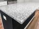 Close-up of kitchen island featuring a sleek, white granite countertop on dark base cabinets at 304 Torslanda Ln, Summerville, SC 29486