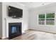 Bright living room featuring a cozy fireplace, large window, and wood-look flooring at 304 Torslanda Ln, Summerville, SC 29486