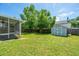 Green backyard featuring a storage shed, lush lawn, and a screened porch at 311 Aberdeen Cir, Summerville, SC 29483