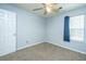 Bedroom with ceiling fan, window with blue curtain, and door at 311 Aberdeen Cir, Summerville, SC 29483