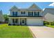 Charming two-story home featuring a manicured lawn, gray siding, black shutters, and a two car garage at 311 Aberdeen Cir, Summerville, SC 29483
