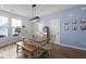 Bright dining room with a rustic wooden table, bench seating, modern light fixture, and a charming blue accent wall at 330 Ripple Park Dr, Summerville, SC 29486