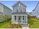 Inviting two-story home with a charming front porch, seating area, lush lawn, and well-maintained landscaping at 330 Ripple Park Dr, Summerville, SC 29486