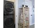 Functional laundry area features a stacked washer/dryer and a wood shelving system for organized storage at 330 Ripple Park Dr, Summerville, SC 29486