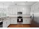 Well-lit kitchen includes stainless steel appliances, granite countertops, and white cabinets at 3927 Four Poles Park Dr, North Charleston, SC 29405