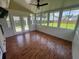 Bright sunroom with wood floors, ceiling fan, and multiple windows overlooking the backyard at 412 Beverly Dr, Summerville, SC 29485