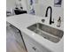 Kitchen island featuring white countertops, stainless steel sink, and black faucet with access to a modern dishwasher at 437 Caledon Ct, Johns Island, SC 29455