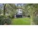 Exterior of home with stairway, grass and trees draped with Spanish moss at 4601 Apple St, North Charleston, SC 29405