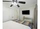 Bright bedroom featuring ceiling fan, TV, and large bed with decorative striped blanket at 4601 Apple St, North Charleston, SC 29405