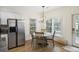 Kitchen area with stainless steel refrigerator and breakfast nook with windows at 4601 Apple St, North Charleston, SC 29405