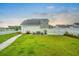 Spacious backyard with a well-maintained lawn, seating area, white picket fence, and detached garage at 501 Rhythm St, Summerville, SC 29486